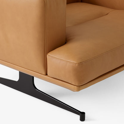 Pur_Norsk Inland AV21 lenestol fra &Tradition, detalj av cognacfarget hud og sort understell.